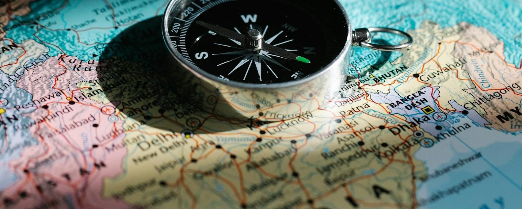 A close-up shot of a compass resting on a map of India, symbolizing exploration and travel.